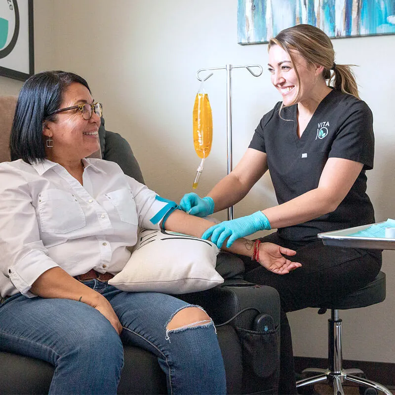 concierge-patient-experience Vita 10 staff member smiling and administering an IV to a smiling patient